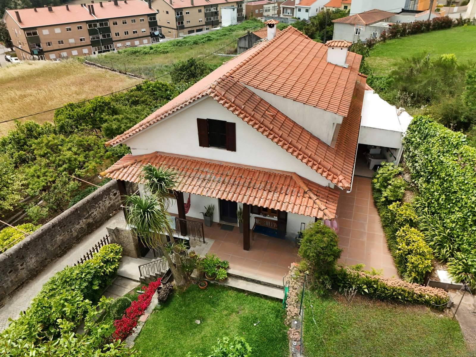 Vista aérea de la casa con tejado de teja, terraza y jardín