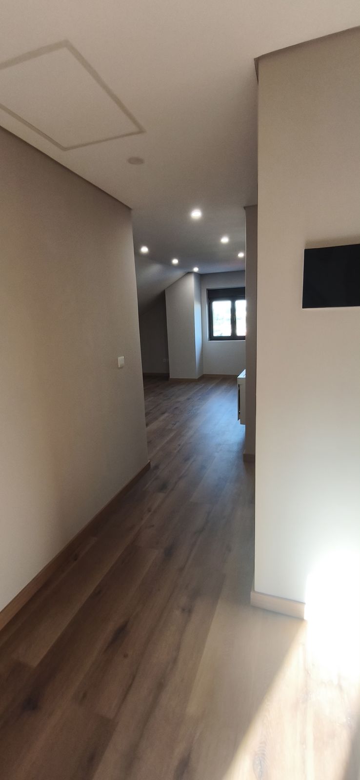 Pasillo con suelo de madera y focos empotrados